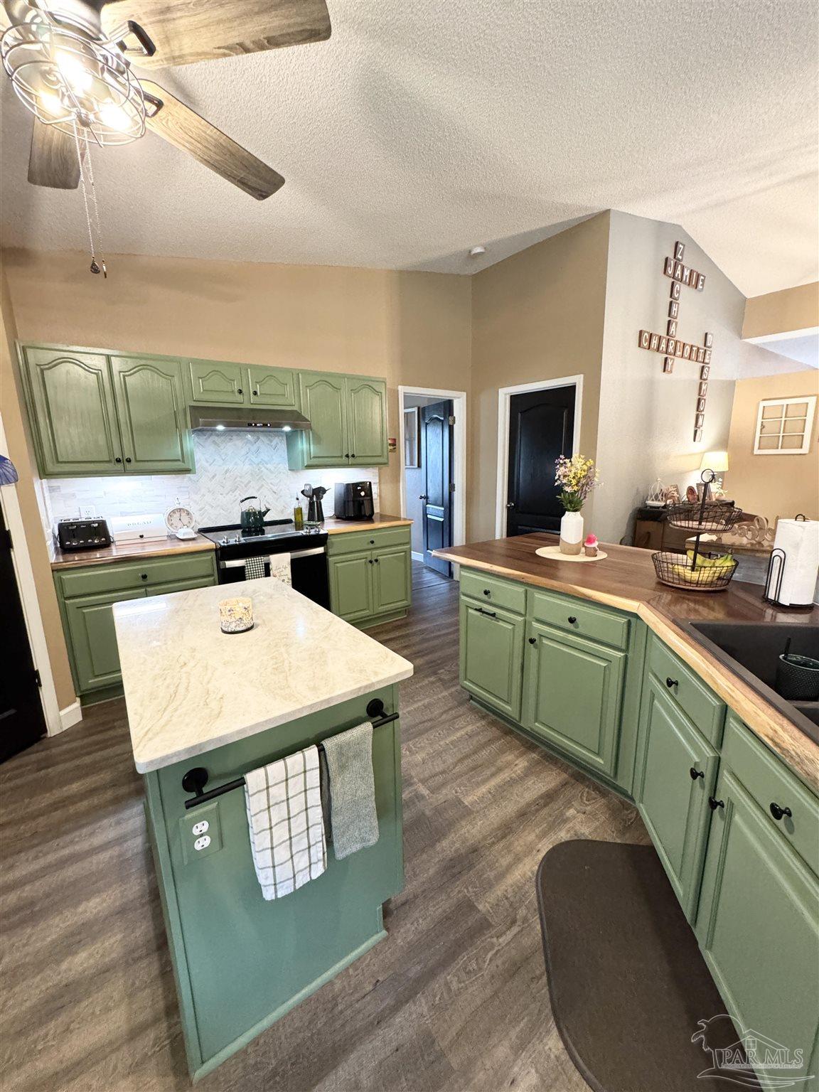 9909 South Trace Road Milton, FL 32583 - Photo 13 of 41 a kitchen with a stove a sink and a refrigerator