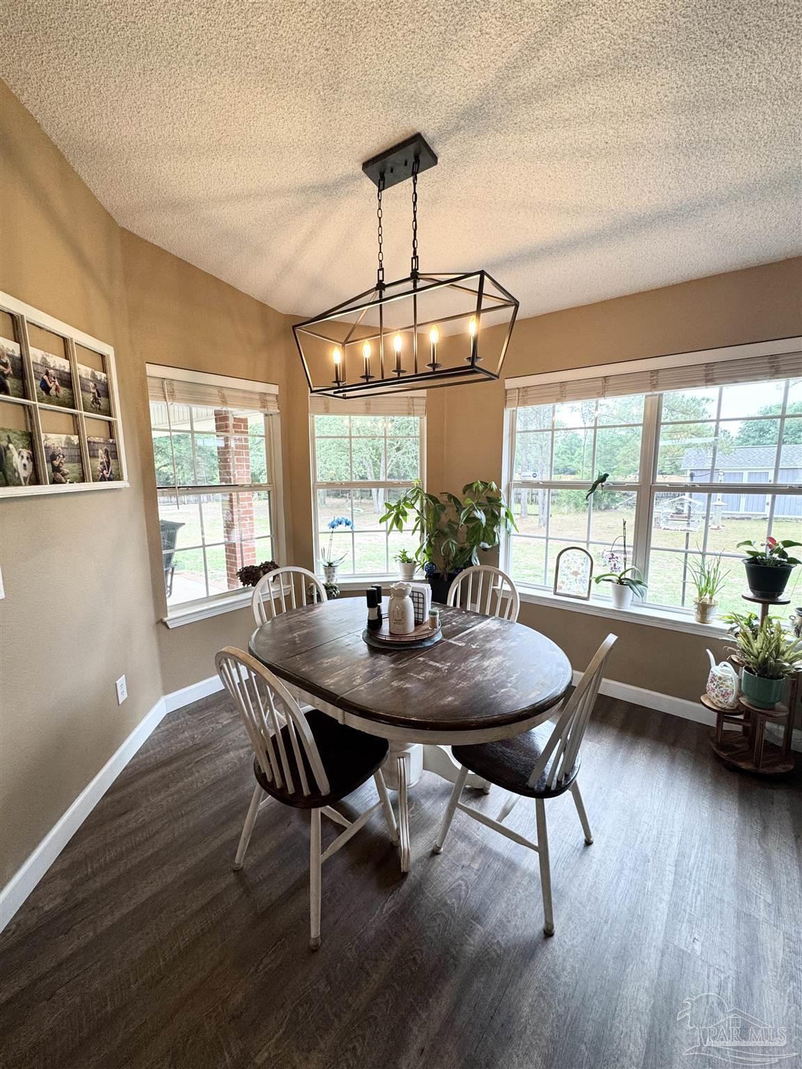 9909 South Trace Road Milton, FL 32583 - Photo 14 of 41 a dining room with furniture window wooden floor