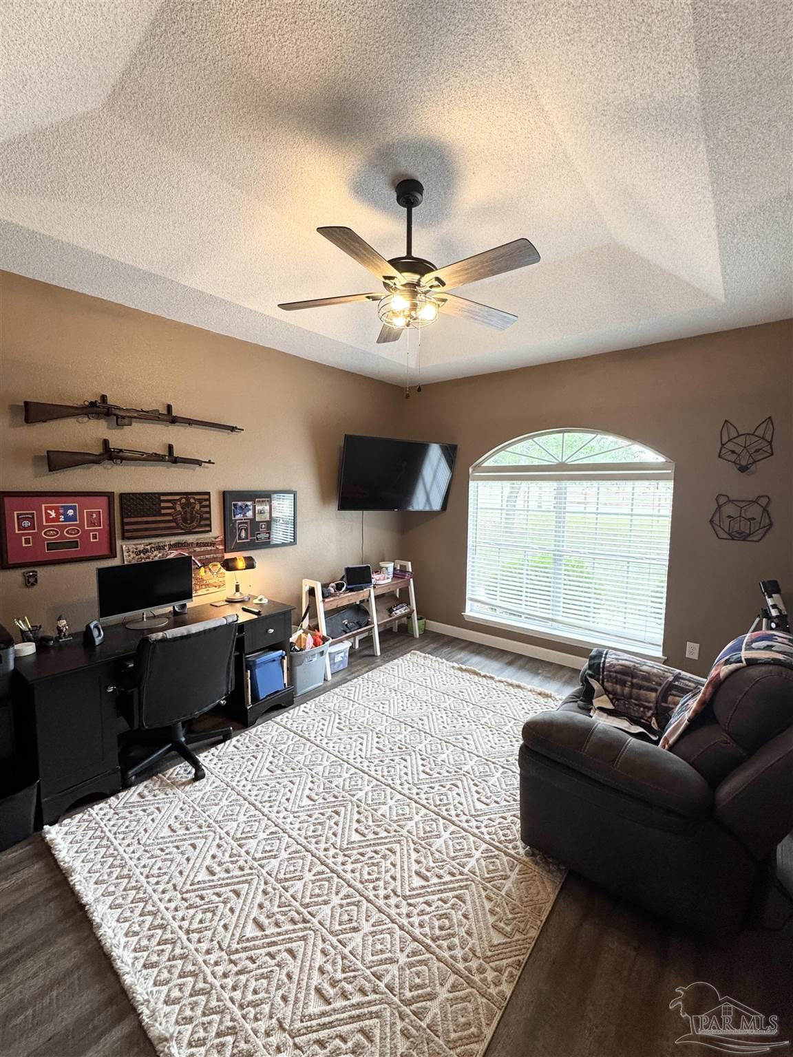 9909 South Trace Road Milton, FL 32583 - Photo 16 of 41 a living room with furniture a flat screen tv and a large window