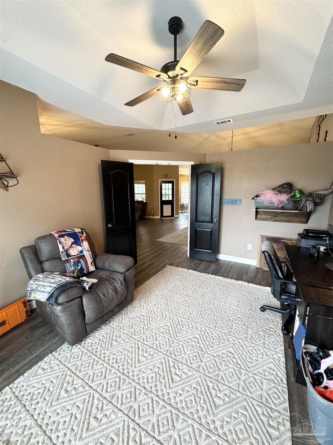 9909 South Trace Road Milton, FL 32583 - Photo 17 of 41 a bedroom with furniture and a chandelier