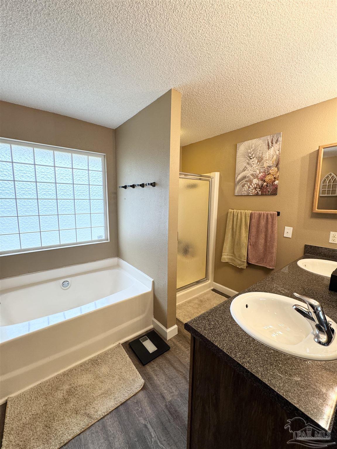 9909 South Trace Road Milton, FL 32583 - Photo 20 of 41 a bathroom with a sink double vanity and a bathtub
