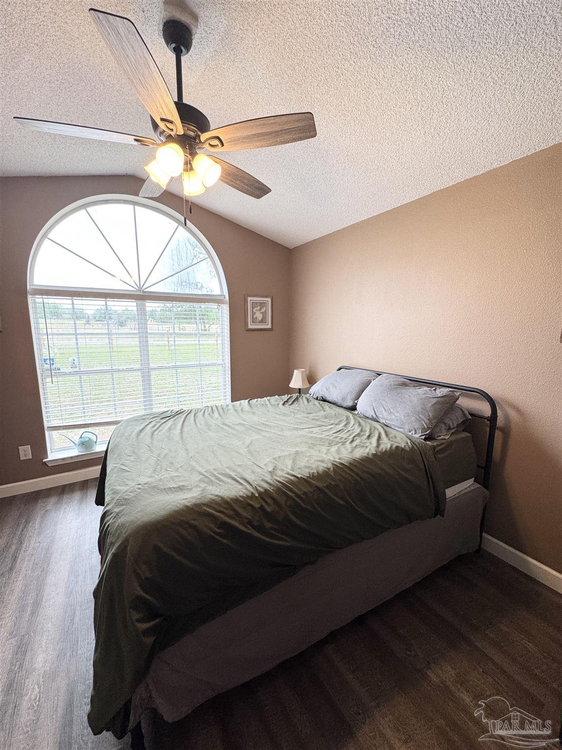 9909 South Trace Road Milton, FL 32583 - Photo 23 of 41 a bedroom with a large bed and a large window