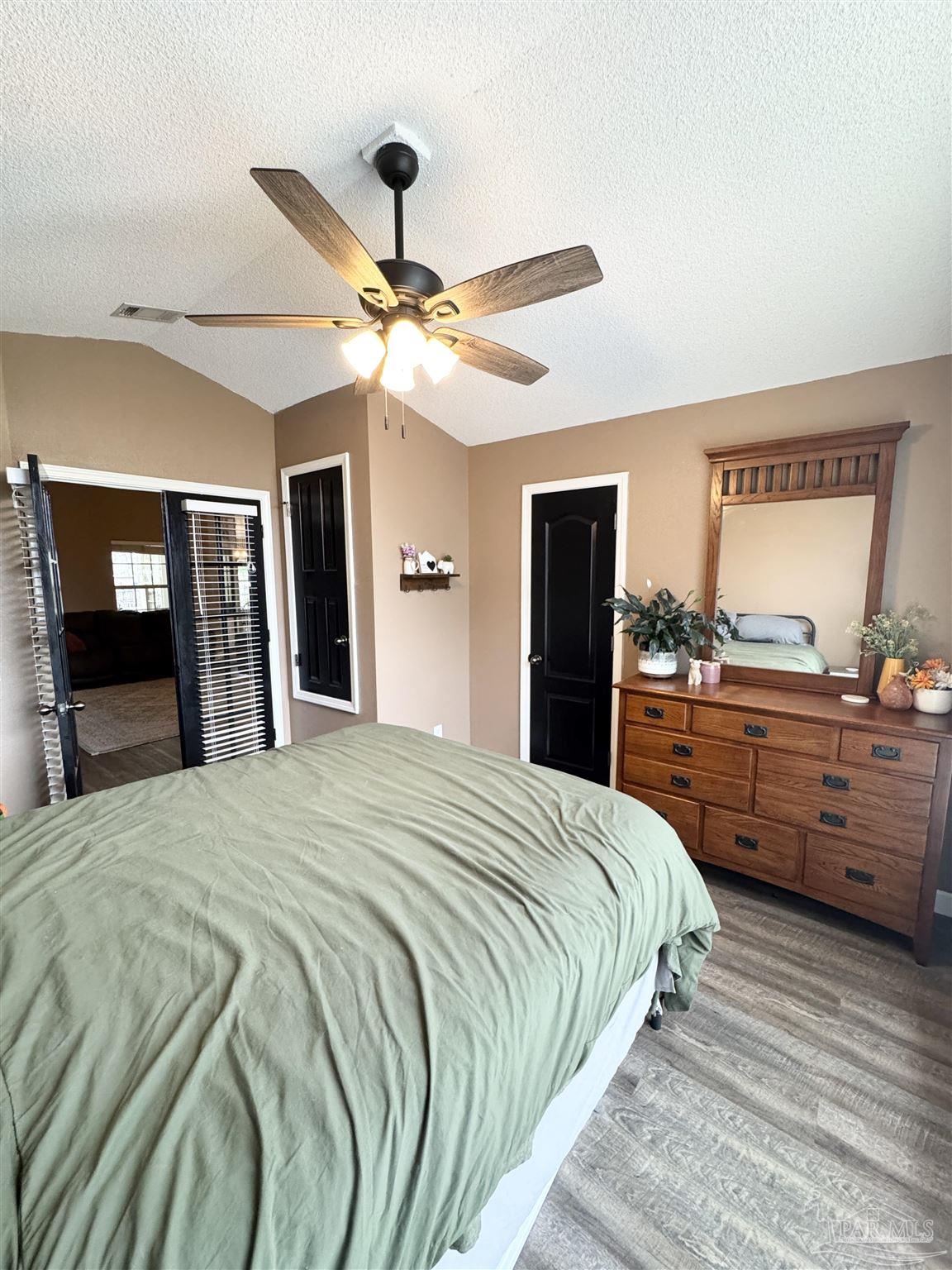 9909 South Trace Road Milton, FL 32583 - Photo 24 of 41 a bedroom with a bed and a large mirror