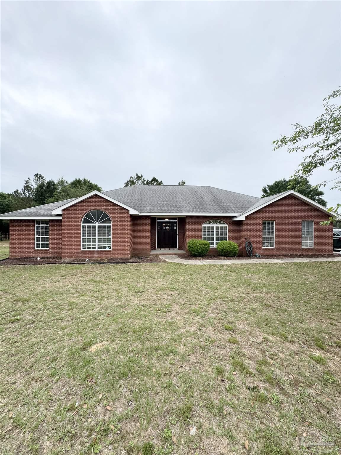9909 South Trace Road Milton, FL 32583 - Photo 3 of 41 a view of a big house with a yard