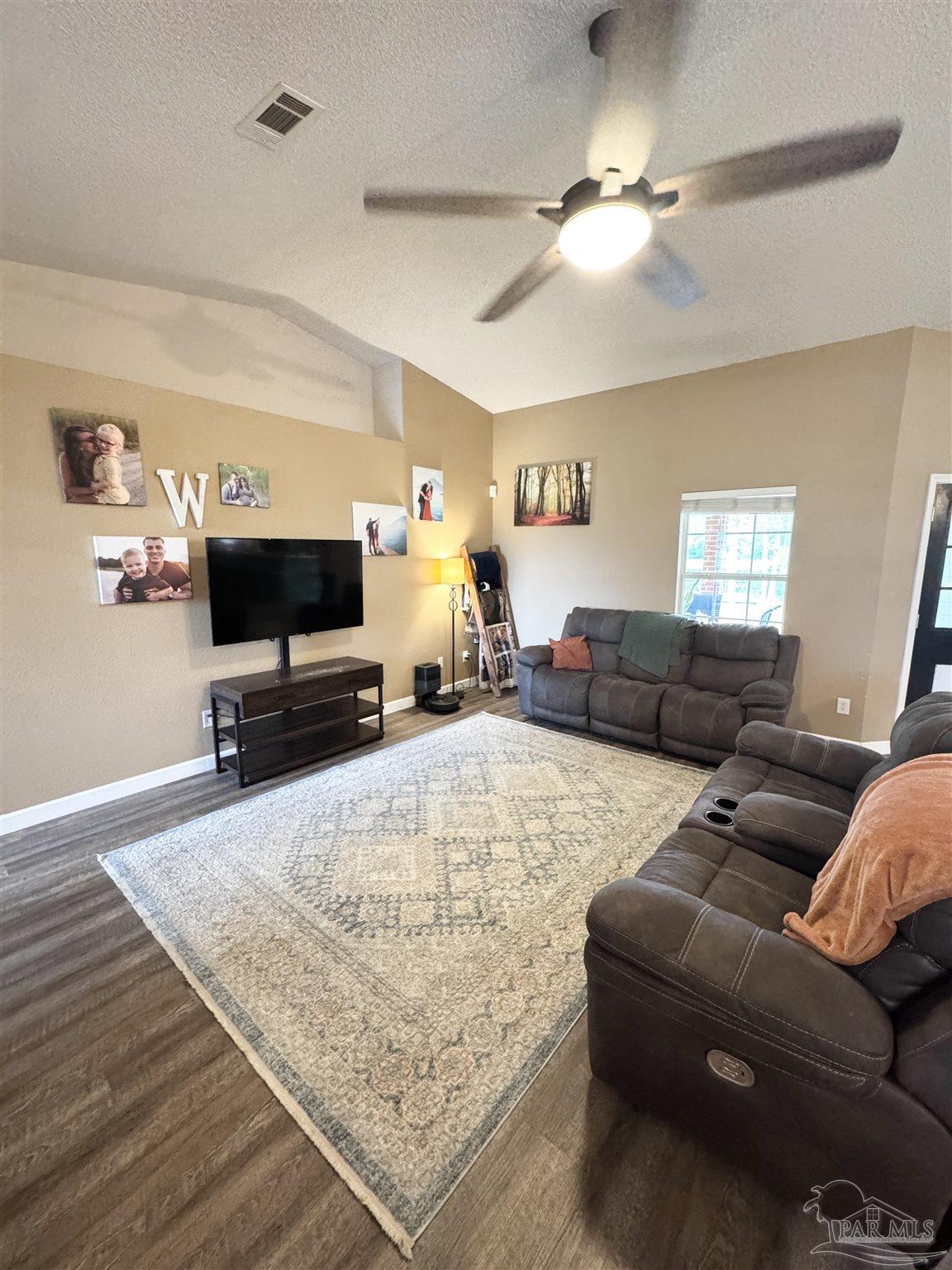 9909 South Trace Road Milton, FL 32583 - Photo 5 of 41 a living room with furniture and a flat screen tv