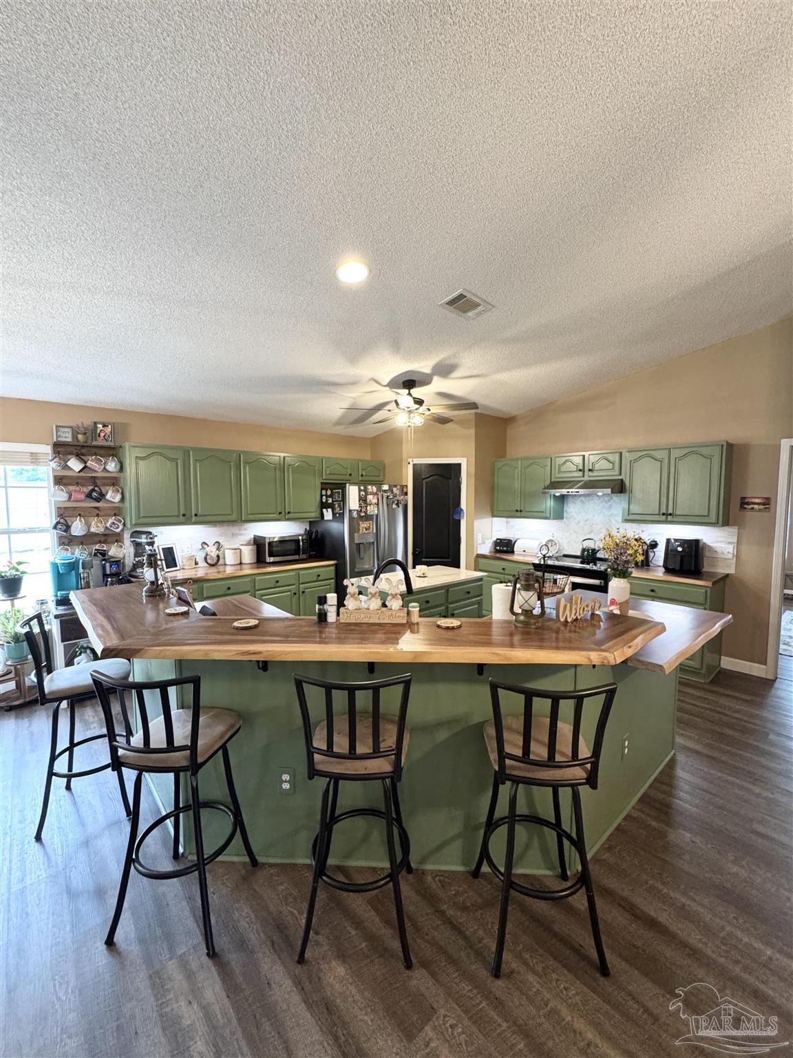 9909 South Trace Road Milton, FL 32583 - Photo 7 of 41 a dining hall with stainless steel appliances a dining table and chairs with wooden floor