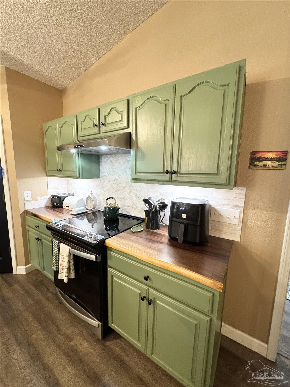 9909 South Trace Road Milton, FL 32583 - Photo 8 of 41 a kitchen with stainless steel appliances wooden cabinets sink and stove