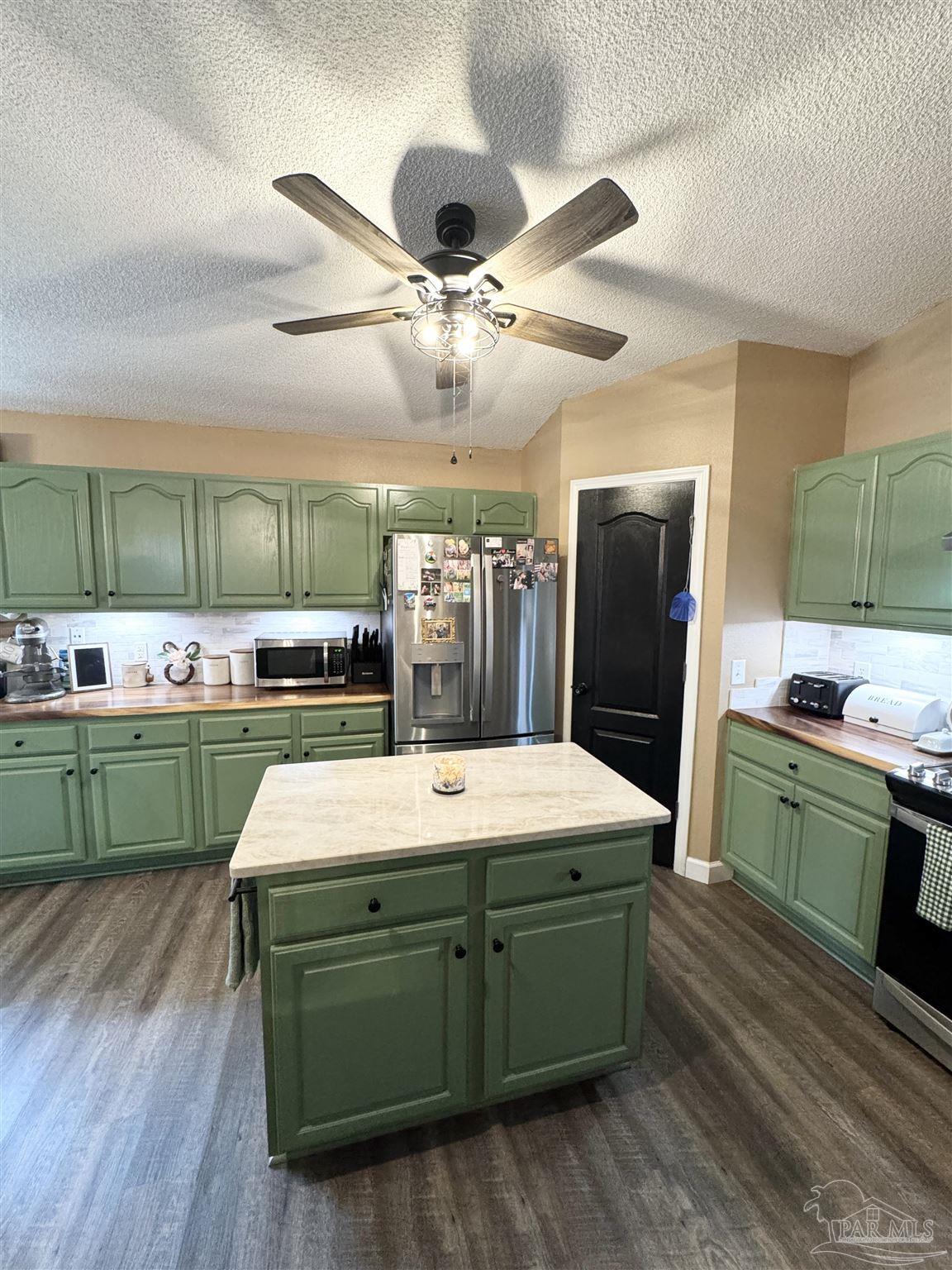 9909 South Trace Road Milton, FL 32583 - Photo 9 of 41 a room with kitchen island stainless steel appliances furniture and a kitchen