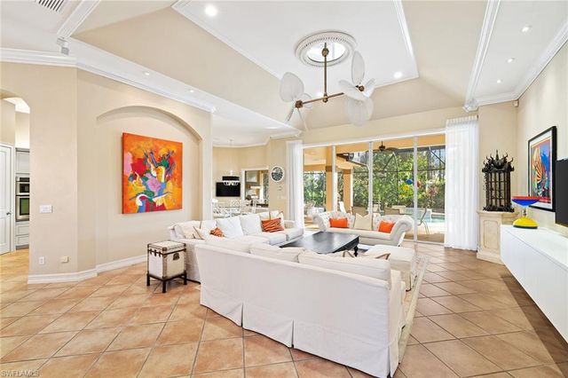 a living room with furniture a flat screen tv and a floor to ceiling window