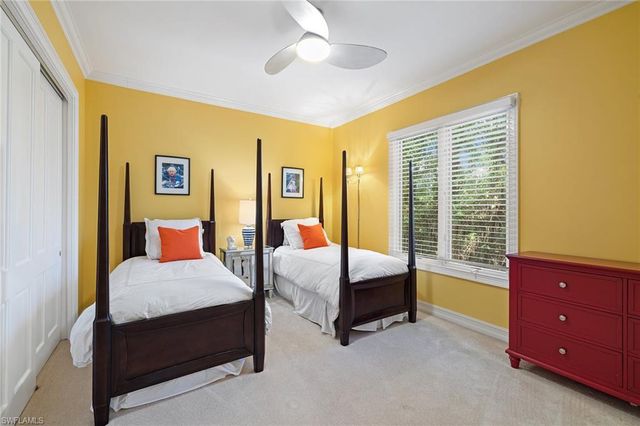 a bedroom with a bed and a dresser next to a window