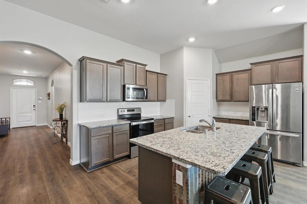 a kitchen with a stove a refrigerator and a sink