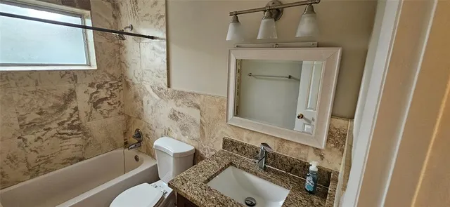 an empty room with wooden floor closet and windows