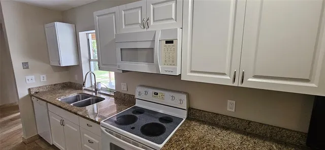 a bathroom with a granite countertop sink a mirror and shower
