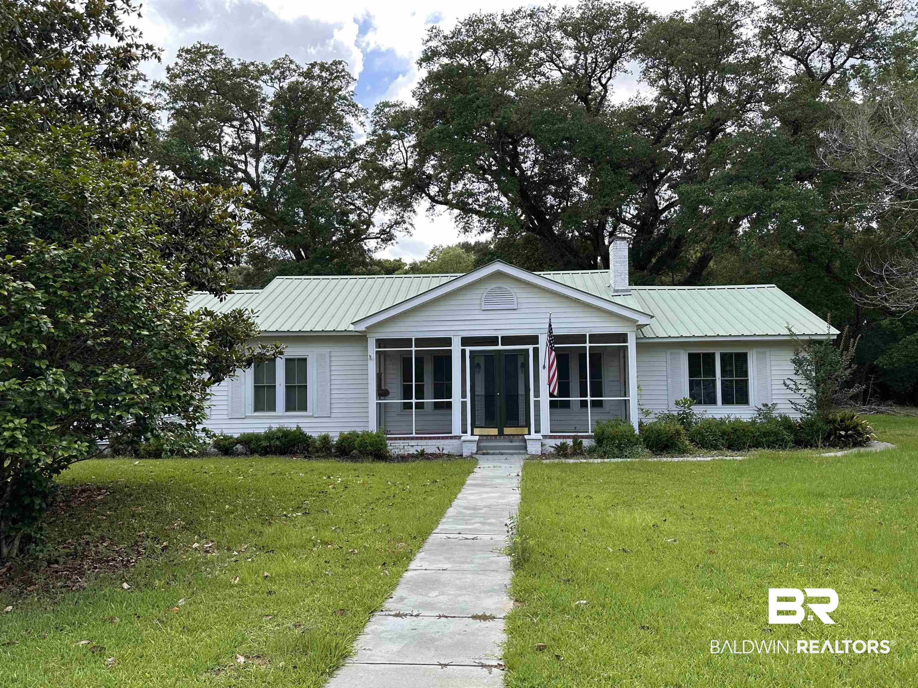 25461 Coopers Cemetery Road Robertsdale, AL 36567 - Photo 1 of 1 Single story home featuring a sunroom, a front lawn, a chimney, and a metal roof