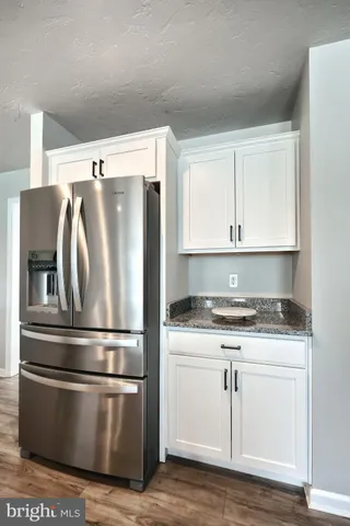 a kitchen with granite countertop white cabinets and stainless steel appliances