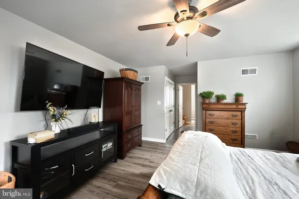 a bedroom with a bed and a mirror on the dresser