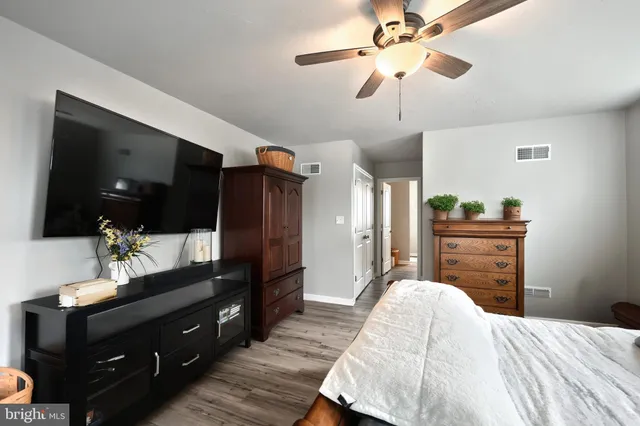 a bedroom with a bed and a mirror on the dresser