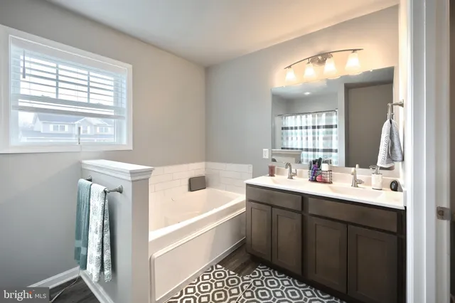 a bathroom with a tub sink and mirror