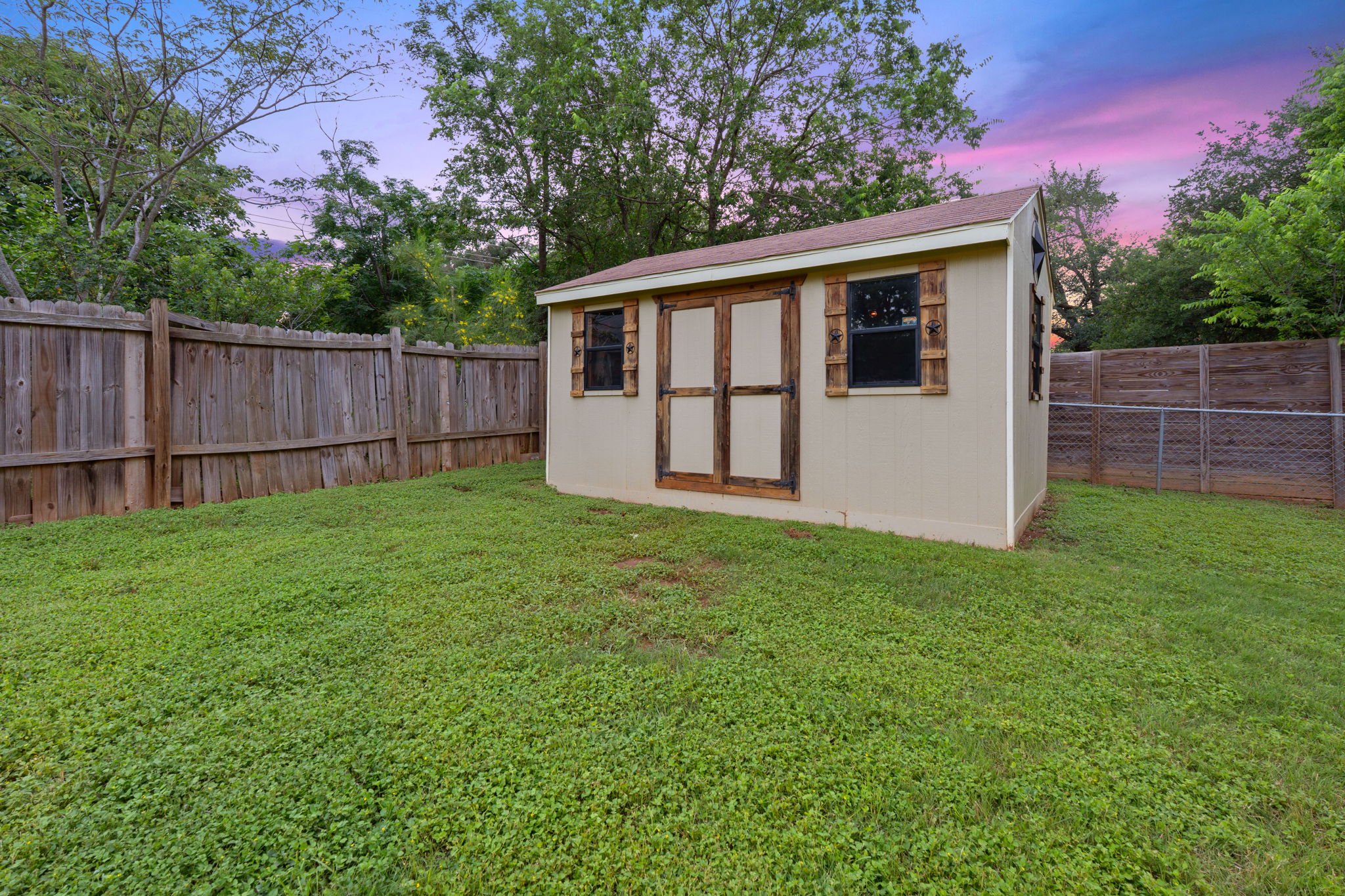 2702 Calabash Cove Austin, TX 78745 - Photo 35 of 40 a view of a backyard with a large tree and wooden fence