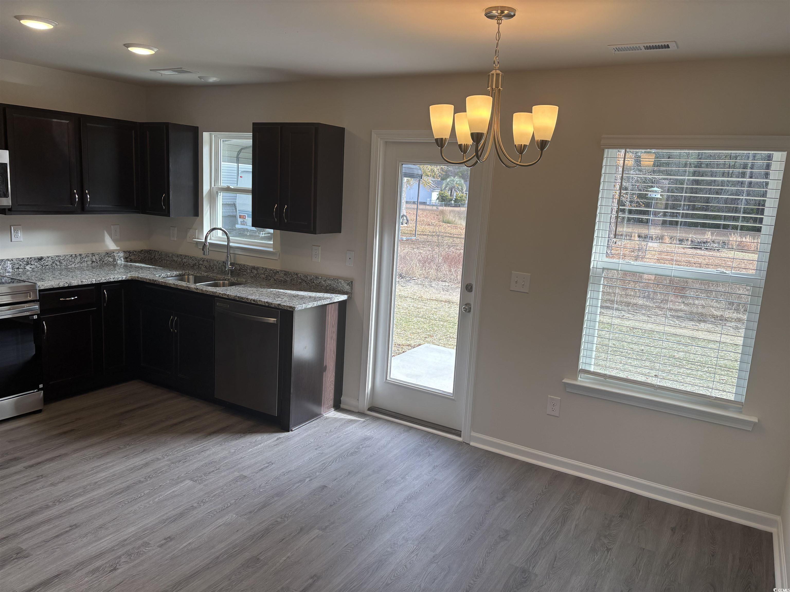 201 Kc Lane Aynor, SC 29511 - Photo 4 of 8 Kitchen featuring light stone counters, hanging light fixtures, dishwasher, stainless steel stove, and dark wood-style flooring