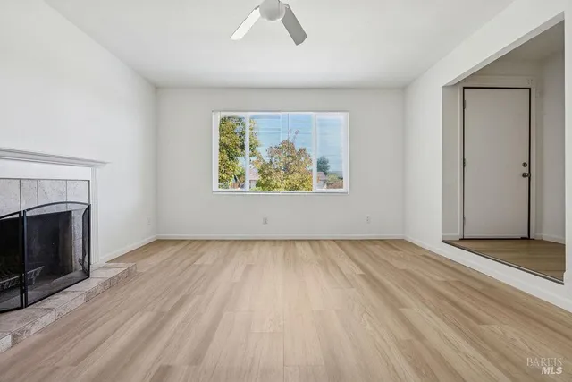 an empty room with windows and a fireplace