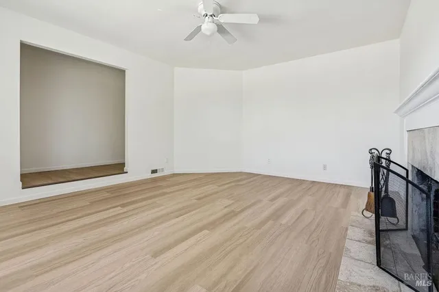 a view of a room with wooden floor and ceiling fan