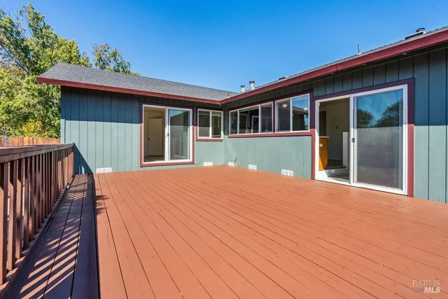 a view of a backyard with large trees and wooden fence