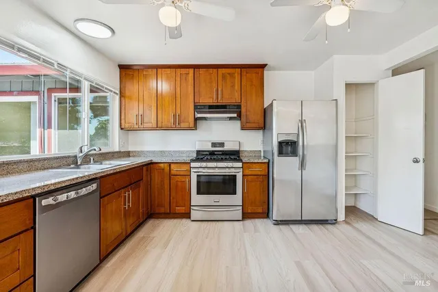 a kitchen with stainless steel appliances a stove a sink and a refrigerator