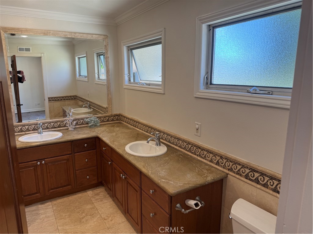 20182 Kline Drive Newport Beach, CA 92660 - Photo 14 of 39 a bathroom with a granite countertop sink a toilet and a mirror