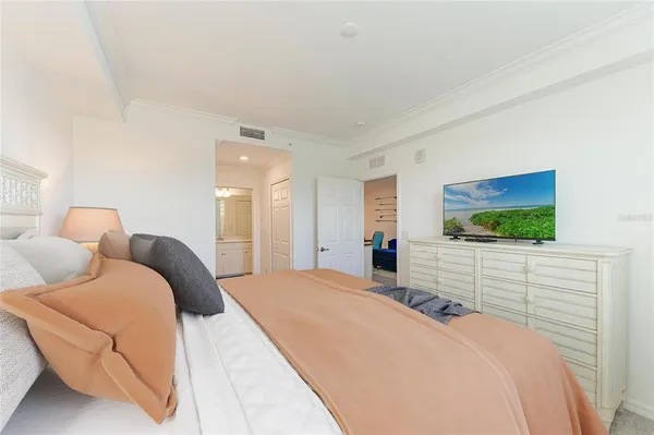 a bedroom with a large bed and a chandelier