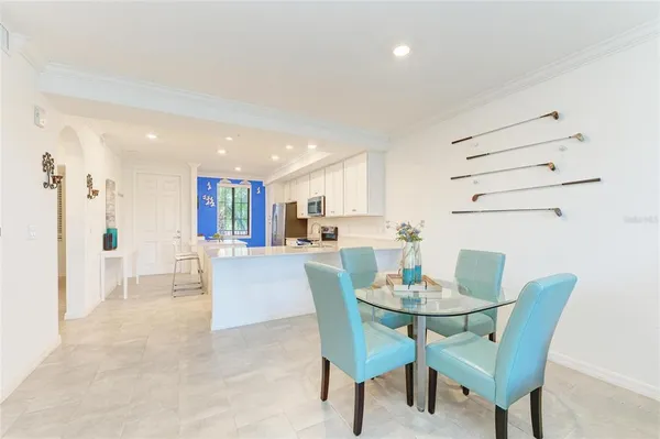 a kitchen with stainless steel appliances a sink a stove a refrigerator cabinets and a dining table