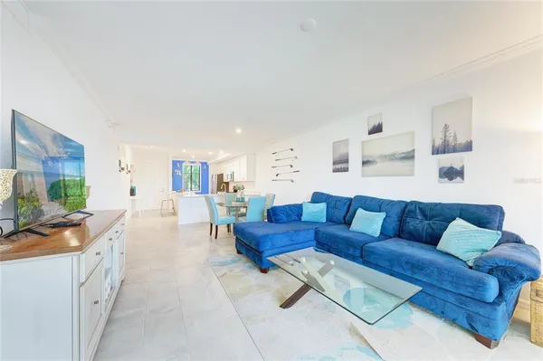a kitchen with stainless steel appliances kitchen island granite countertop a table chairs and a refrigerator