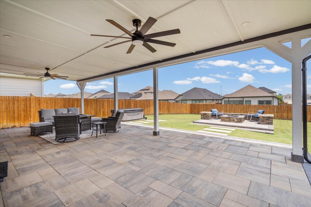158 Gullivers Drive Elgin, TX 78621 - Photo 24 of 36 Look at this massive covered patio! They’ve added dual, oversized multi-blade ceiling fans and recessed lighting overhead, so you can comfortably lounge or dine outdoors even on warm summer evenings.