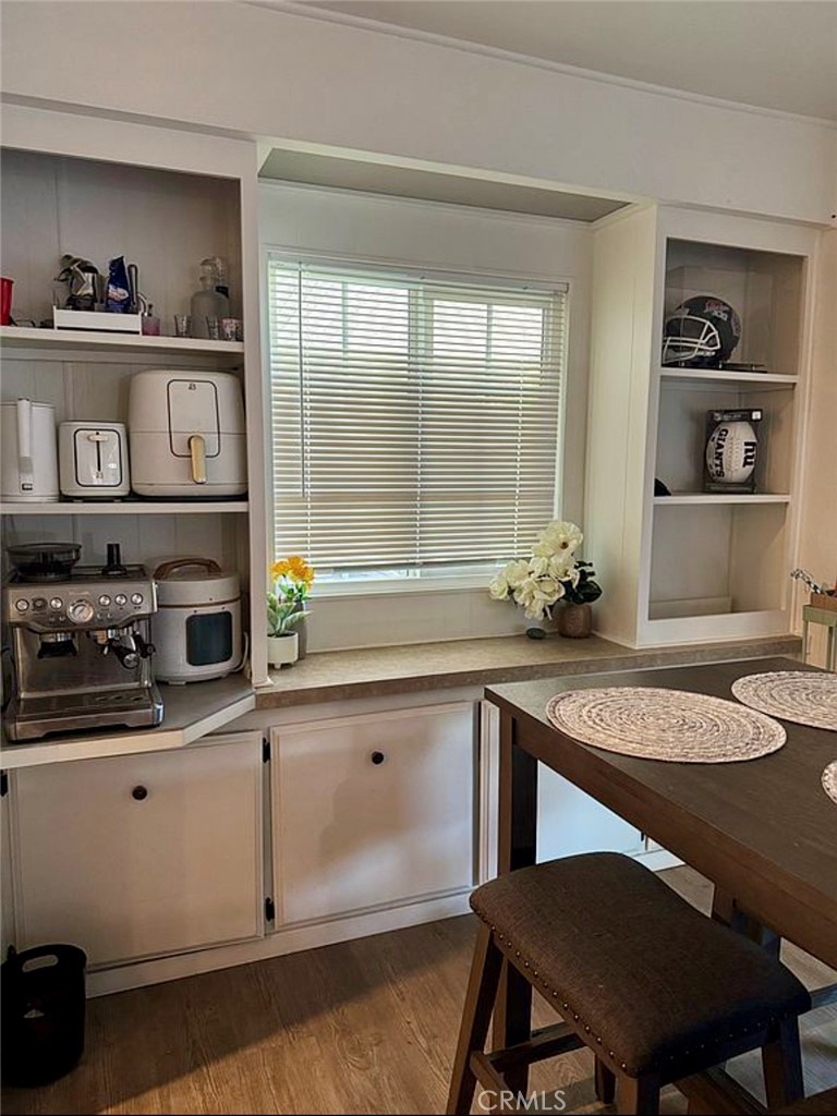 22601 Bear Valley Road, Unit 63 Apple Valley, CA 92308 - Photo 12 of 31 a kitchen with a table chairs stove and cabinets
