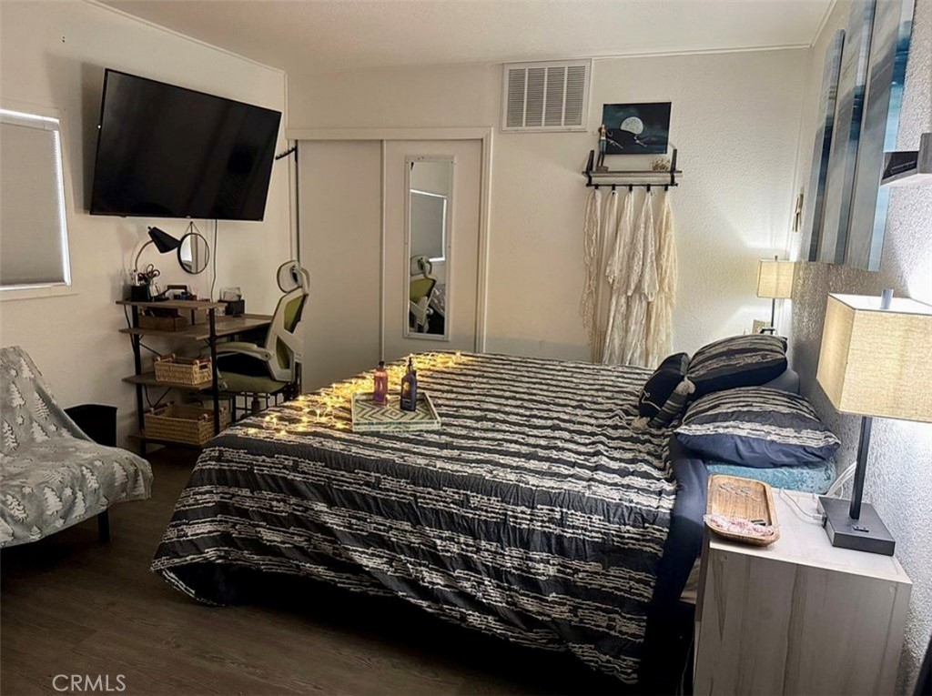 22601 Bear Valley Road, Unit 63 Apple Valley, CA 92308 - Photo 14 of 31 a bedroom with a bed and a flat screen tv