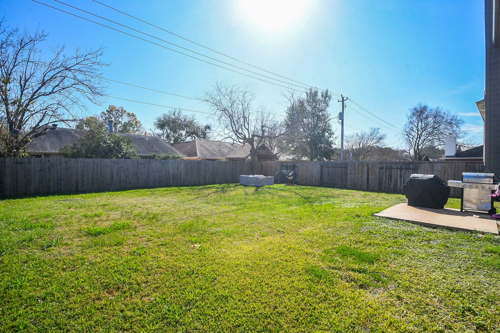 14407 Andrea Way Lane Houston, TX 77083 - Photo 29 of 29 Spacious backyard with a well-maintained lawn, perfect for outdoor activities. The two-story house features a fenced perimeter for privacy and security. Ideal for families or pets.
