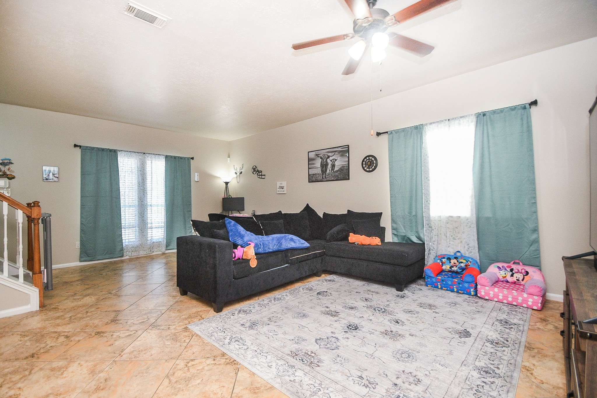 14407 Andrea Way Lane Houston, TX 77083 - Photo 7 of 29 Bright and spacious living room with tiled floors and neutral walls. Features a ceiling fan, and ample natural light from two windows.