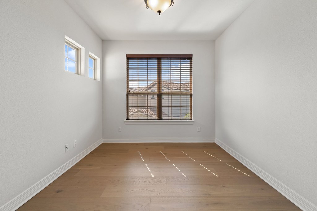 109 Largo Cove Austin, TX 78734 - Photo 24 of 40 Natural light illuminates the rich hardwood flooring in this versatile living space, offering an inviting blank canvas.