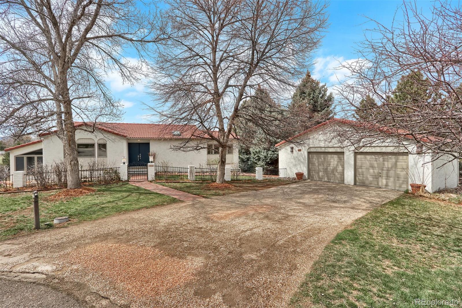 855 Front Range Road Littleton, CO 80120 - Photo 1 of 34 a front view of a house with a yard and garage