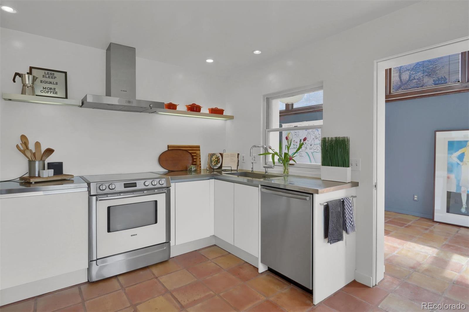 855 Front Range Road Littleton, CO 80120 - Photo 15 of 34 a kitchen with stainless steel appliances granite countertop a stove and white cabinets