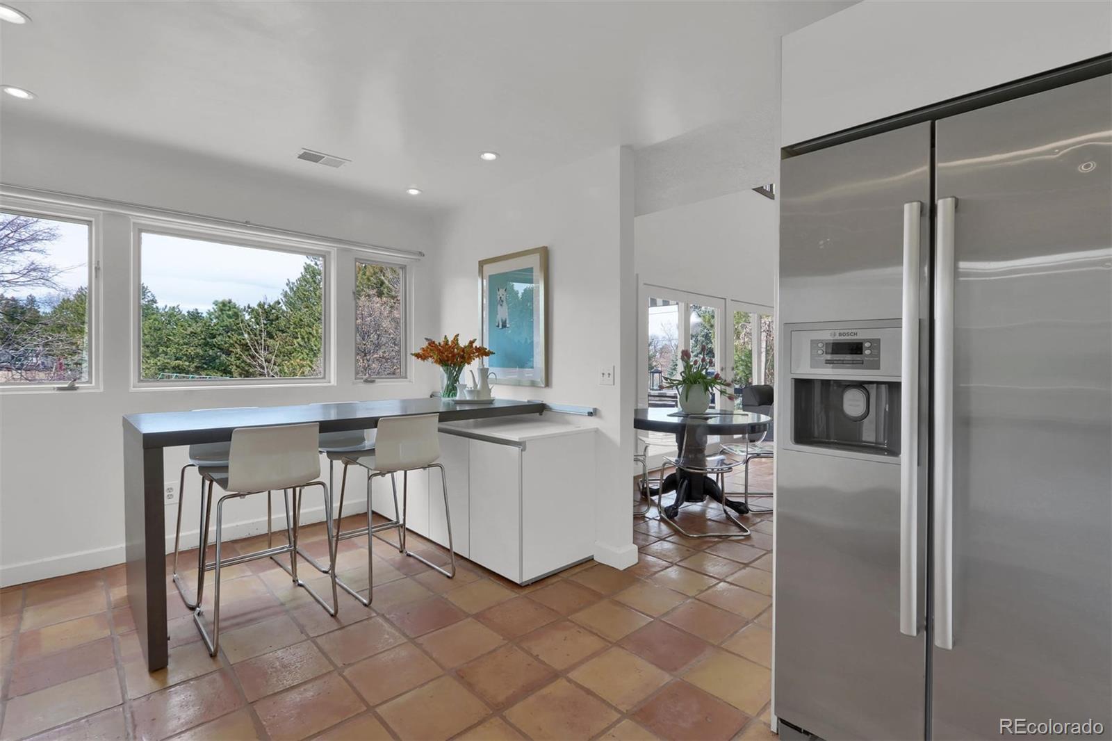 855 Front Range Road Littleton, CO 80120 - Photo 17 of 34 a kitchen with a refrigerator and a table chair