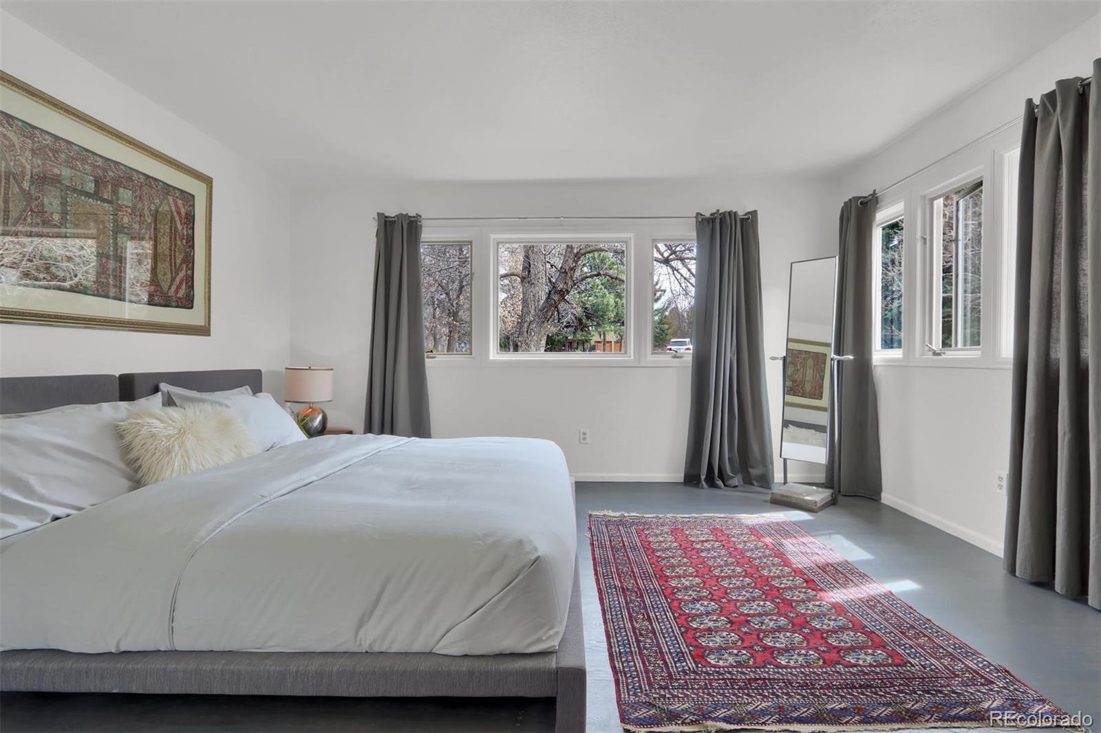 855 Front Range Road Littleton, CO 80120 - Photo 20 of 34 a bedroom with a large bed and a rug