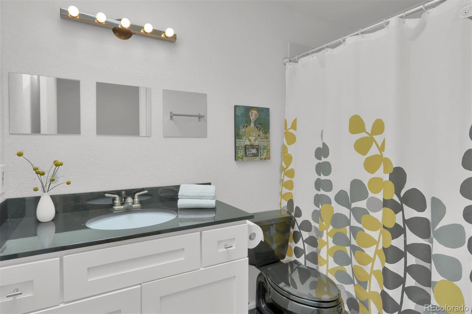 855 Front Range Road Littleton, CO 80120 - Photo 24 of 34 a bathroom with a granite countertop sink a mirror and shower curtain