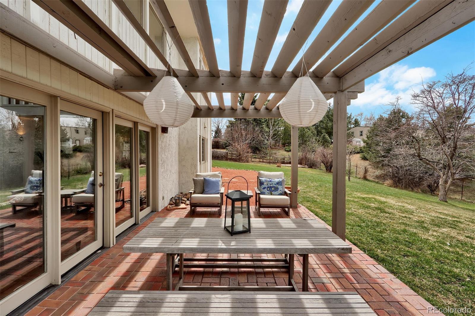 855 Front Range Road Littleton, CO 80120 - Photo 28 of 34 a view of a patio with lawn chairs floor to ceiling window with wooden fence