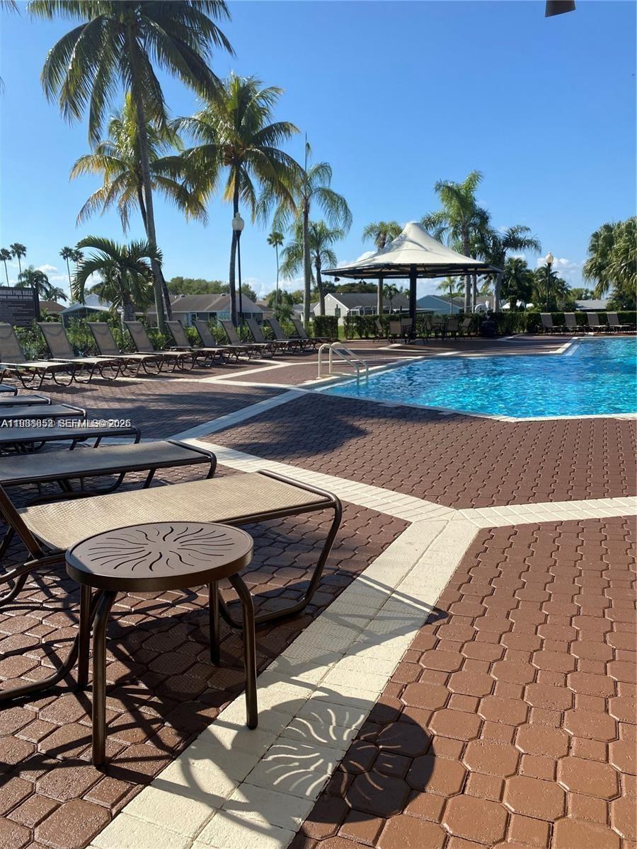 540 Southeast 21st Lane, Unit 540 Homestead, FL 33033 - Photo 13 of 14 a view of a swimming pool with a table and chairs