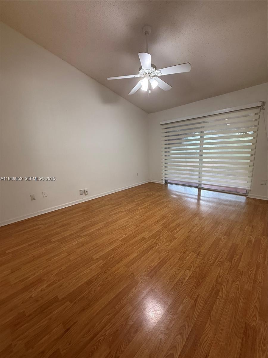 540 Southeast 21st Lane, Unit 540 Homestead, FL 33033 - Photo 3 of 14 an empty room with wooden floor and windows