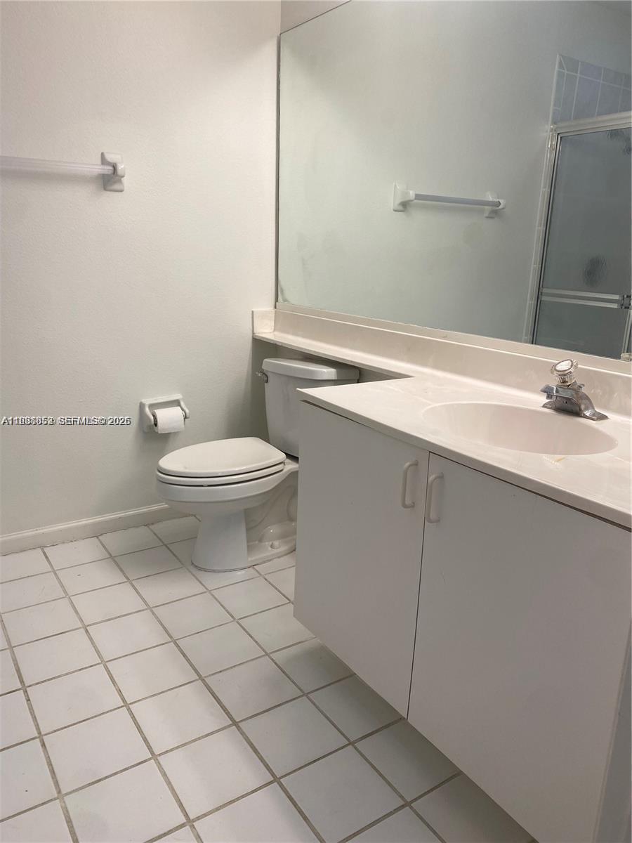 540 Southeast 21st Lane, Unit 540 Homestead, FL 33033 - Photo 8 of 14 a bathroom with a toilet a sink and mirror