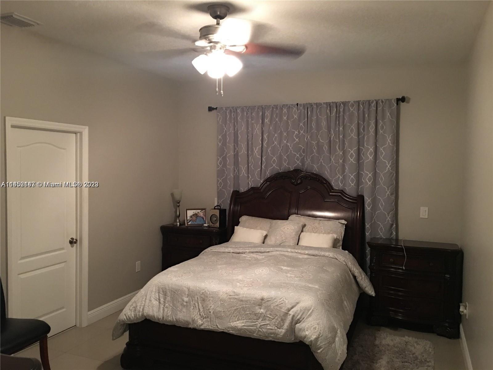 16124 Southwest 55th Terrace Miami, FL 33185 - Photo 11 of 23 a bedroom with a bed and a chandelier