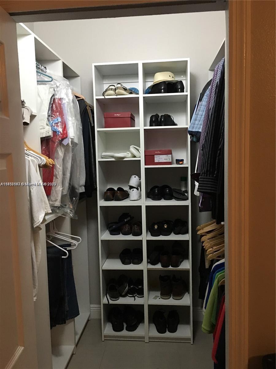 16124 Southwest 55th Terrace Miami, FL 33185 - Photo 13 of 23 a view of walk in closet with clothes and shoes