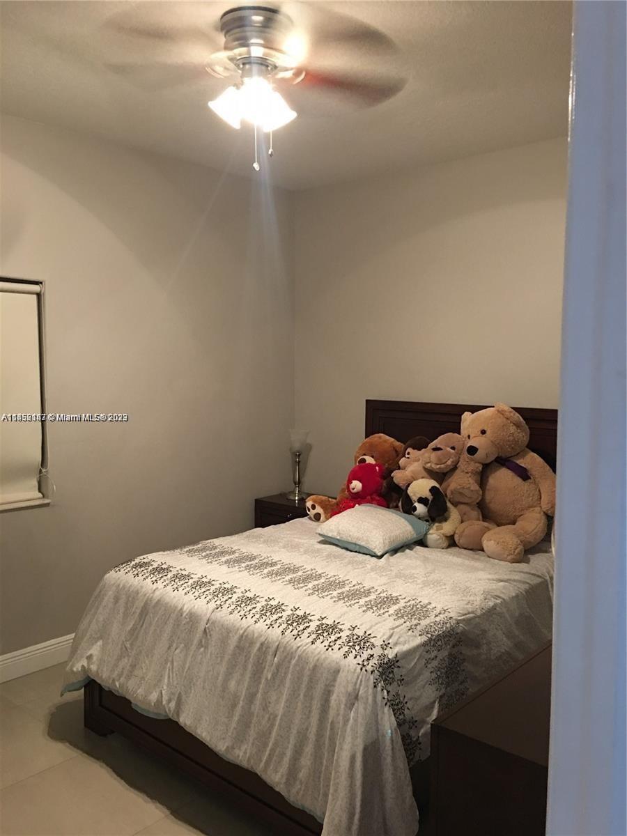 16124 Southwest 55th Terrace Miami, FL 33185 - Photo 17 of 23 a bed sitting in a bedroom next to a window